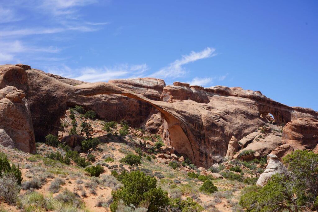 A red rock arch connects stone cliffs at Arches National Park in Utah