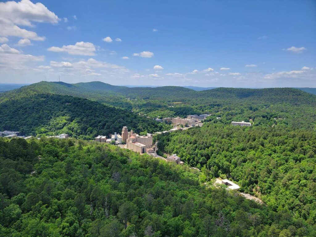 An aerial view of a town surrounded by green forests in Hot Springs National Park, Arkansas, is part of this list of u.s. national parks by state