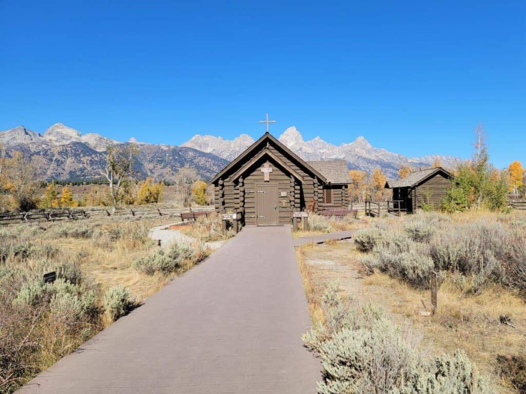 A walkway leading up to a chapel with mountains in the background at Grand Teton National Park.