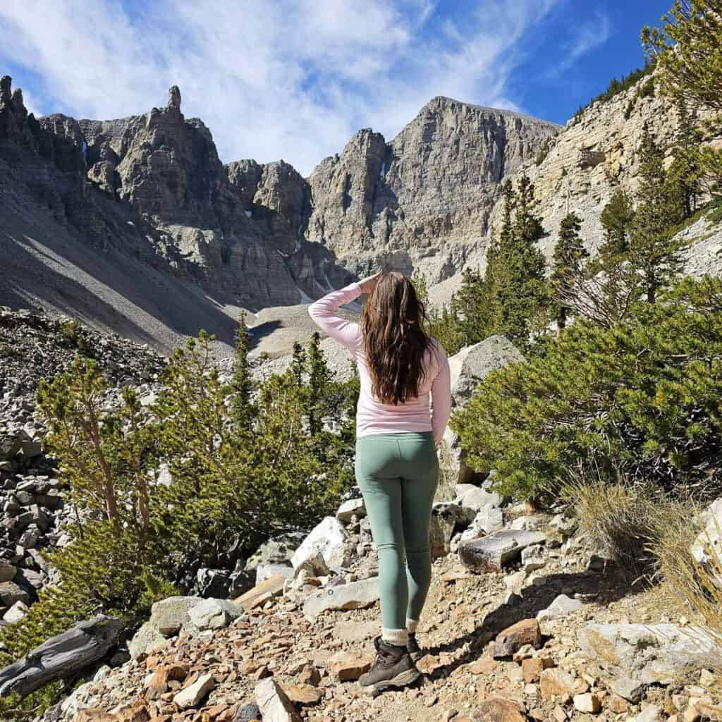 A woman stands looking toward a rocky mountain range at Great Basin National Park in Nevada.